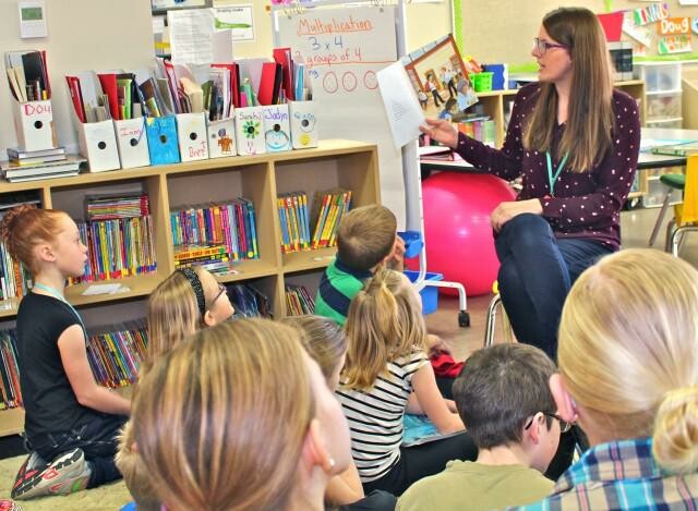 A photo of Westwind's 2015 Edwin Parr Nominee, Allison Groenenboom, reading a book to her students.